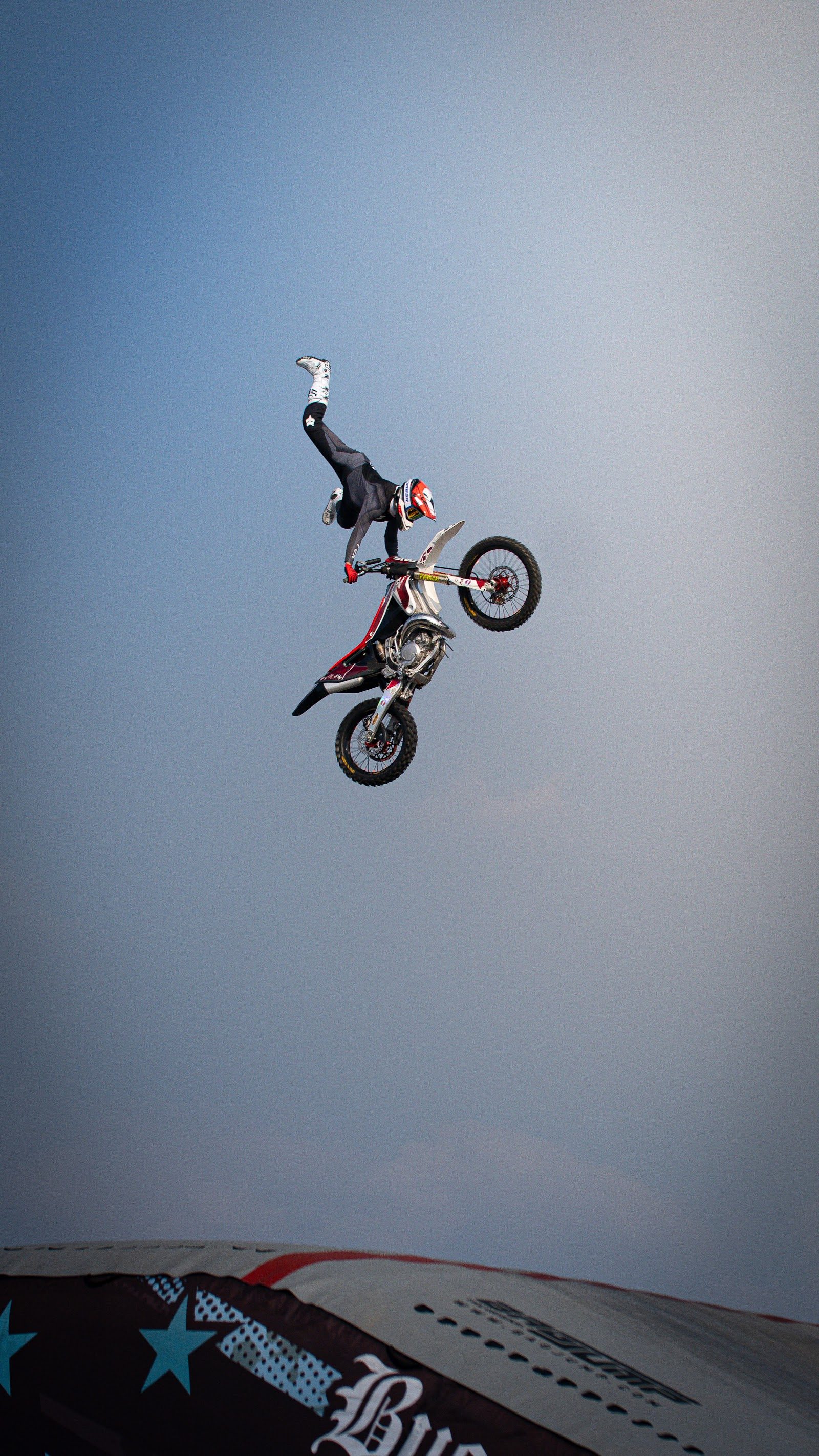 Pilota di motocross freestyle in volo capovolto